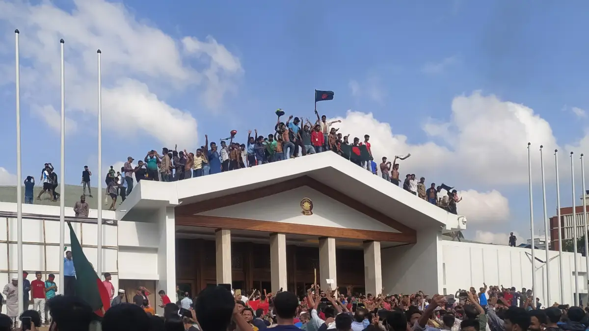 People cheering in front of the Prime Minister's Office after Sheikh Hasina's resignation. Image via Wikipedia by Md Joni Hossain. CC BY-SA 4.0